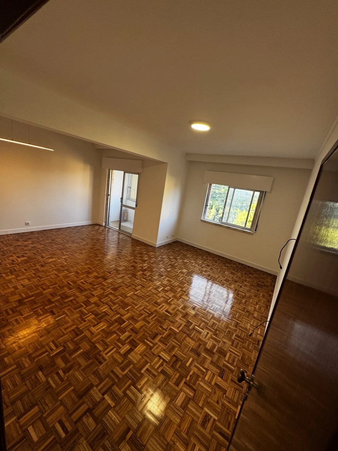 Sala renovada com paredes claras e pavimento restaurado