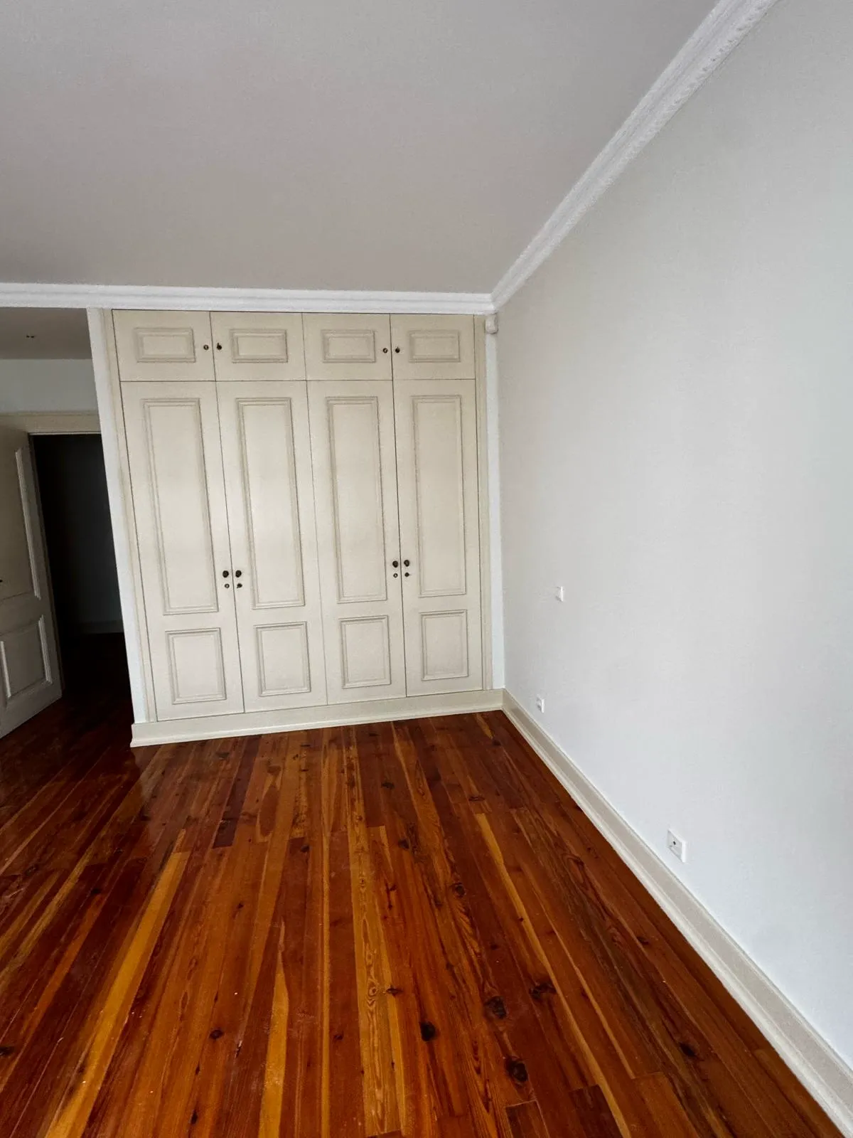 Quarto — paredes brancas e soalho restaurado